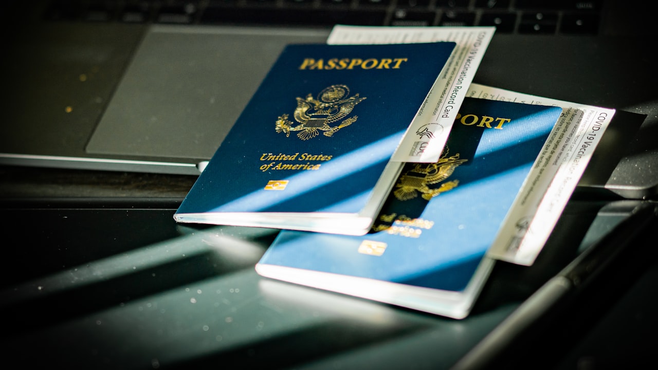 a passport sitting on top of a computer keyboard