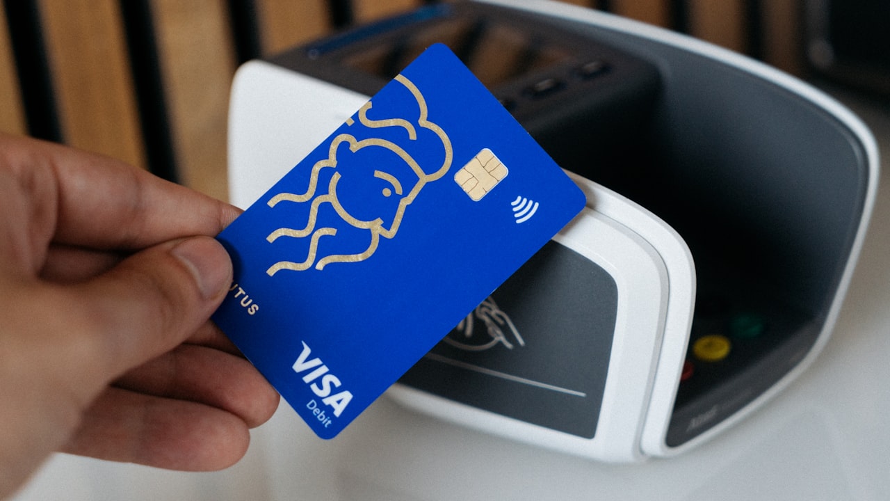 a person is holding a blue credit card