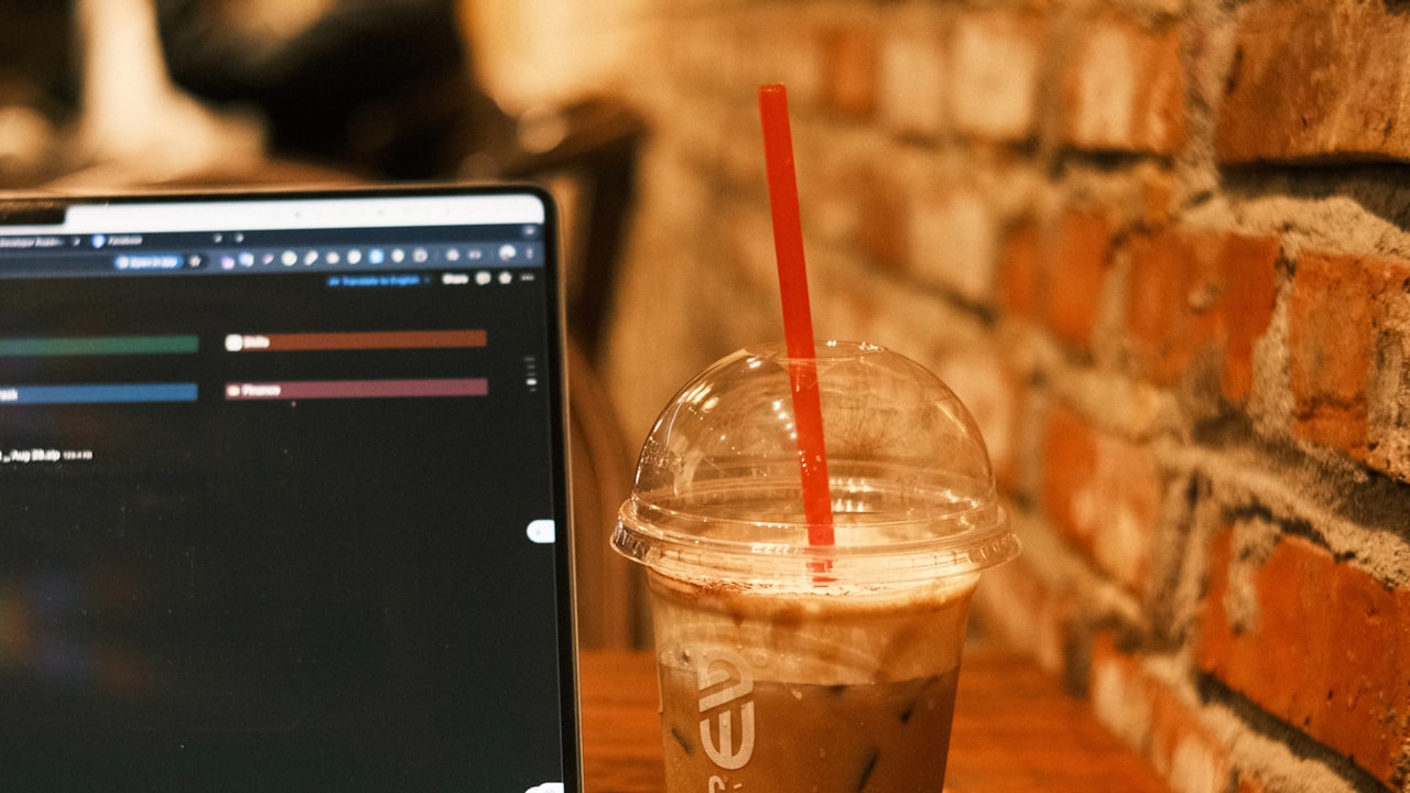 Iced coffee and laptop on a wooden table