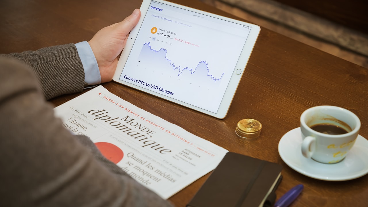 a person sitting at a table with a tablet and a cup of coffee