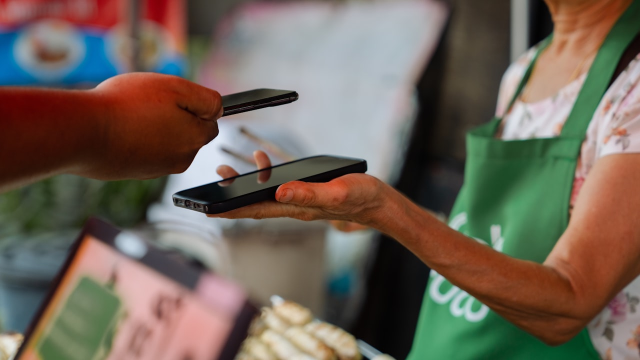 a woman holding two cell phones in her hands