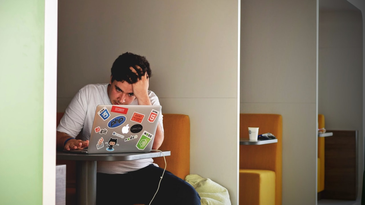man wearing white top using MacBook