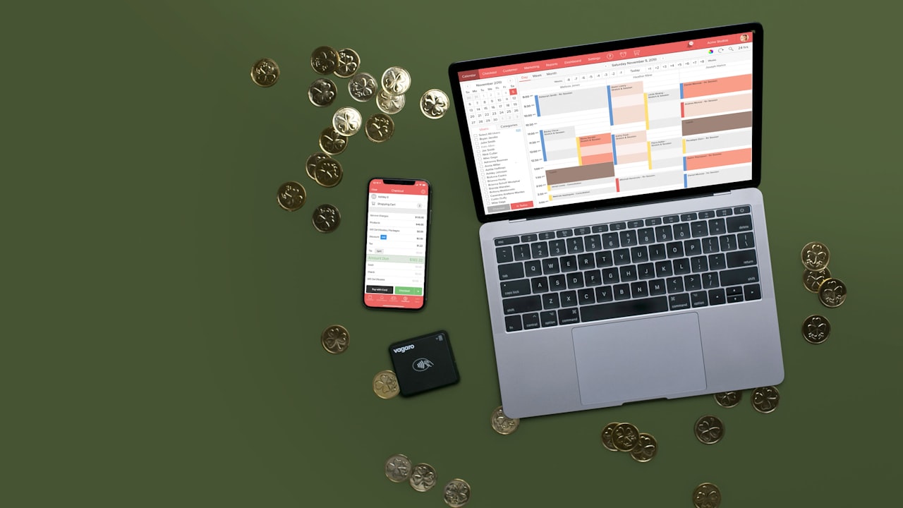 Laptop, phone, and coins on a green surface