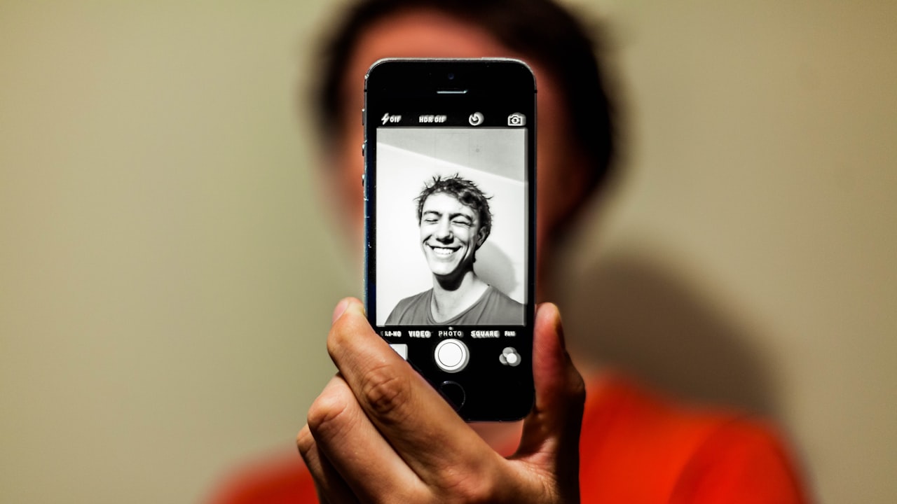 person holding space gray iPhone 5s taking picture