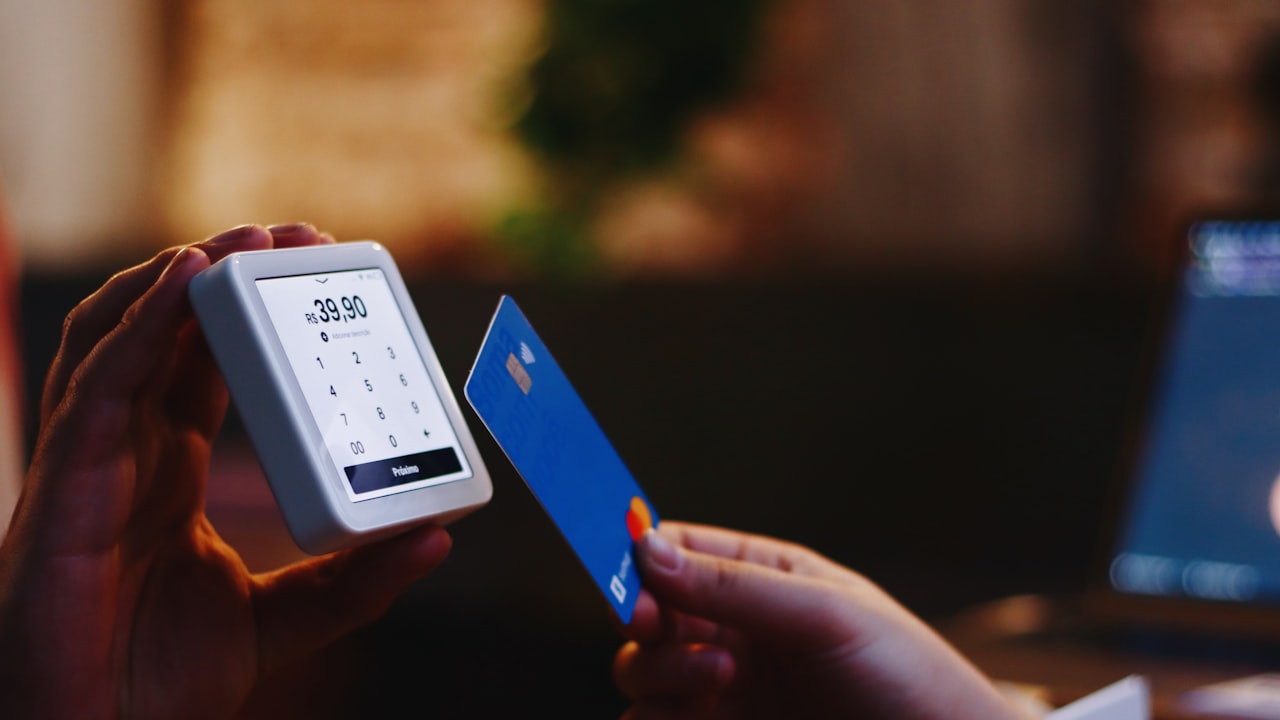 a person holding a credit card and a cell phone